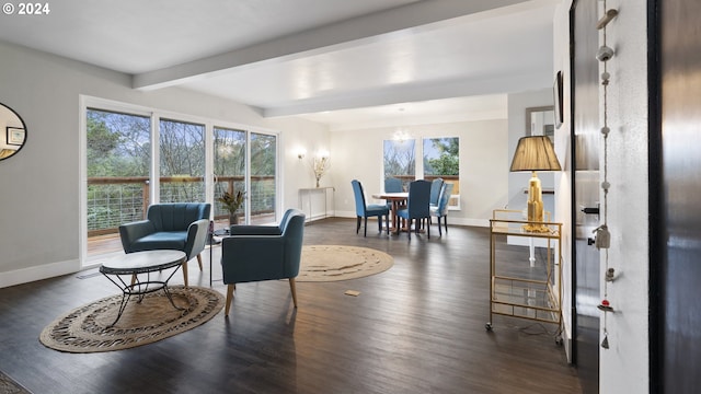 sitting room with baseboards, beamed ceiling, dark wood finished floors, and a healthy amount of sunlight