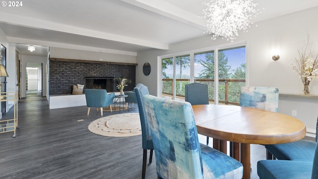 dining space featuring a brick fireplace, a chandelier, beamed ceiling, and wood finished floors