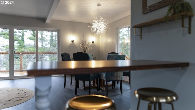 dining area featuring beamed ceiling, wood finished floors, and a notable chandelier