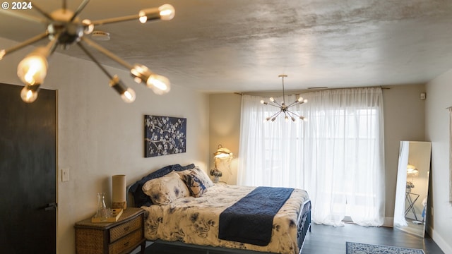 bedroom featuring wood finished floors and an inviting chandelier