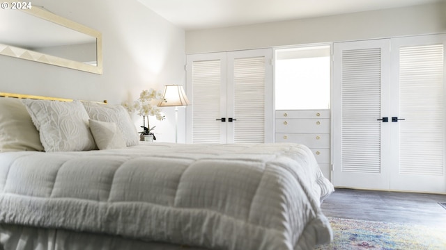 bedroom with multiple closets and wood finished floors