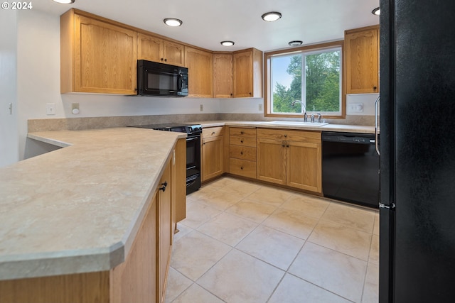 kitchen with sink, light tile flooring, and black appliances