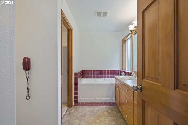 bathroom with tile flooring, a bathtub, and oversized vanity