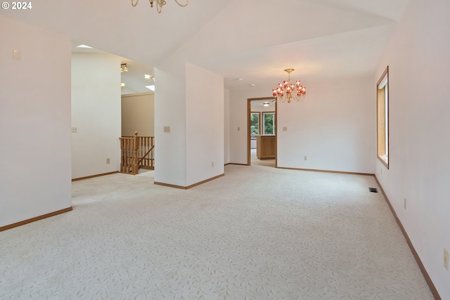 carpeted spare room with a notable chandelier