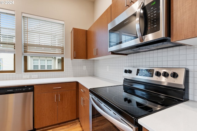 kitchen featuring light wood-type flooring, stainless steel appliances, and tasteful backsplash