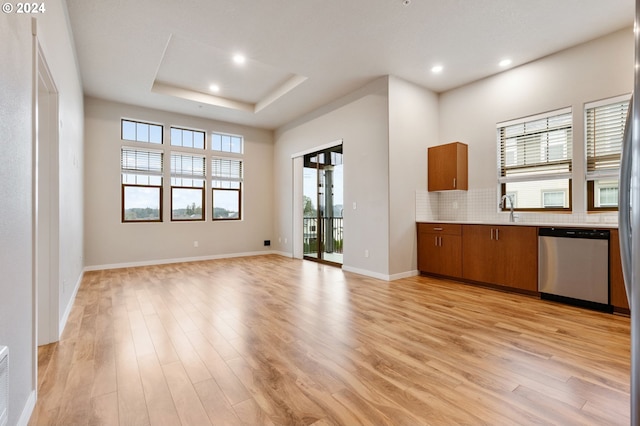 unfurnished living room with a healthy amount of sunlight and light hardwood / wood-style floors