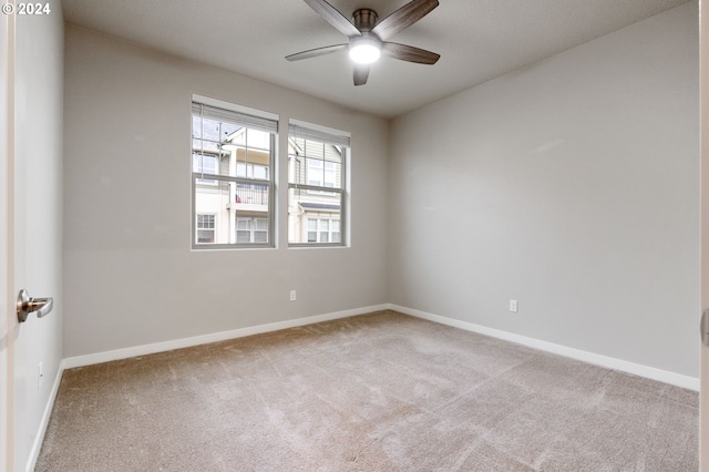 carpeted spare room featuring ceiling fan