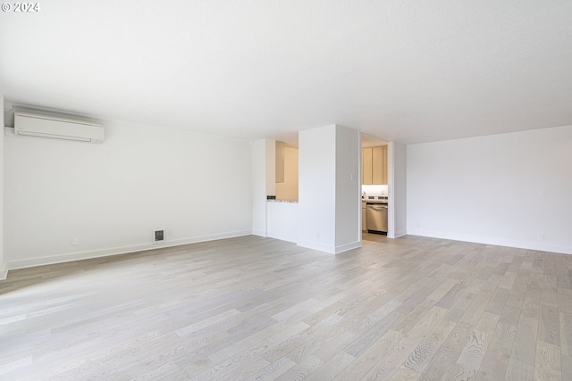 unfurnished living room featuring light hardwood / wood-style flooring and a wall mounted AC