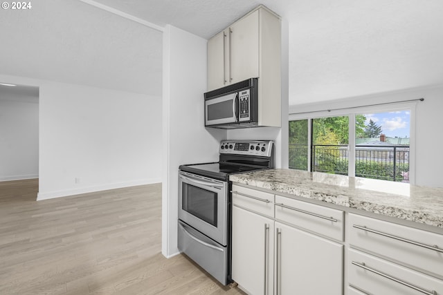 kitchen with white cabinetry, stainless steel electric range oven, light stone counters, and light wood-type flooring