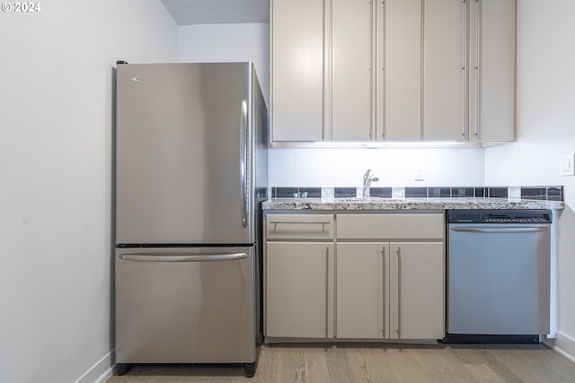 kitchen with sink, light hardwood / wood-style floors, and appliances with stainless steel finishes