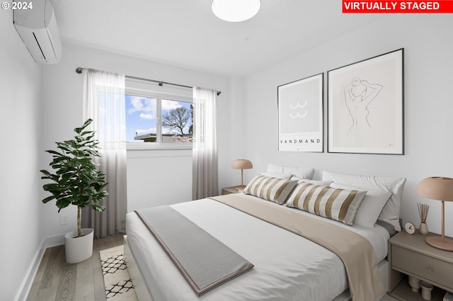 bedroom with hardwood / wood-style floors and a wall mounted AC