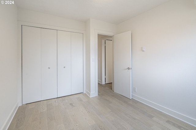 unfurnished bedroom featuring a closet and light hardwood / wood-style floors