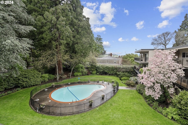 view of swimming pool featuring a yard