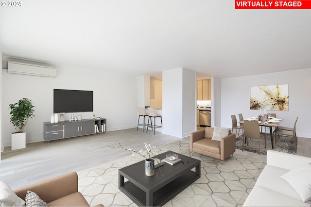 living room with light hardwood / wood-style floors and an AC wall unit