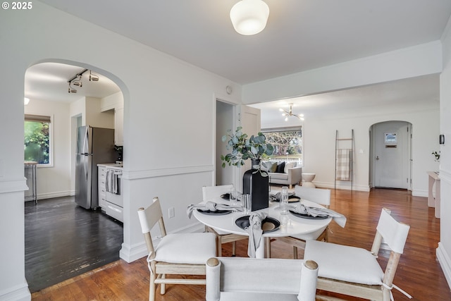 dining room featuring dark hardwood / wood-style floors, a wealth of natural light, and an inviting chandelier