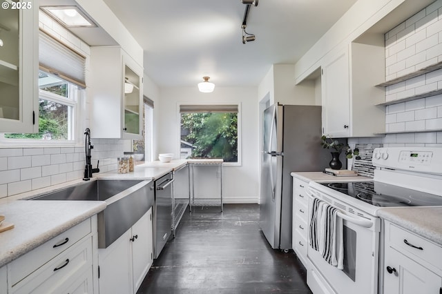 kitchen with sink, white cabinetry, appliances with stainless steel finishes, dark hardwood / wood-style floors, and decorative backsplash