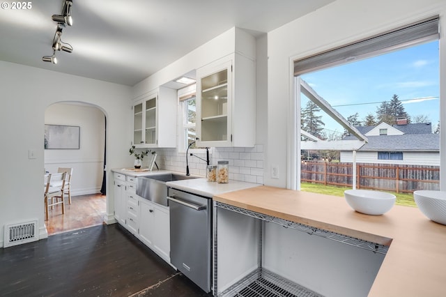 kitchen featuring stainless steel dishwasher, sink, decorative backsplash, and white cabinets