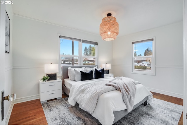 bedroom with hardwood / wood-style floors and ornamental molding