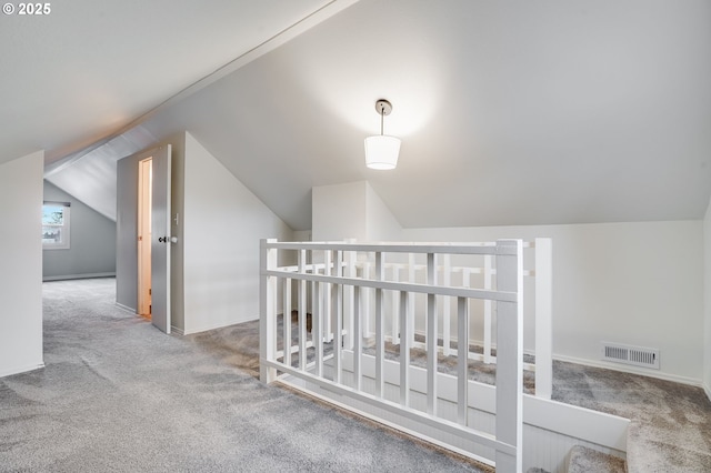 hall with lofted ceiling and carpet floors