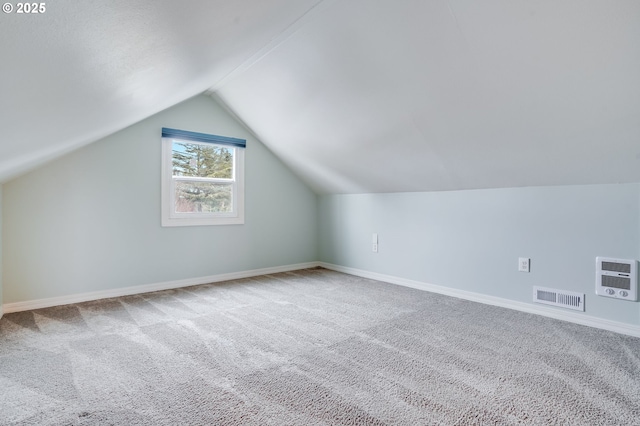 bonus room with vaulted ceiling, carpet floors, and heating unit