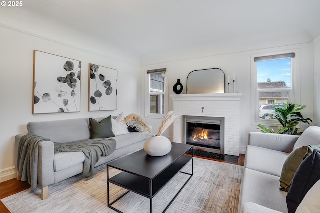 living room with hardwood / wood-style floors and a brick fireplace