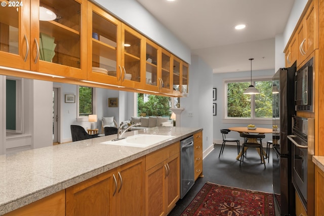 kitchen with glass insert cabinets, stainless steel appliances, a sink, light countertops, and decorative light fixtures