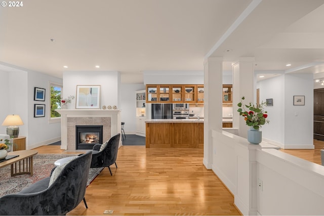 interior space with light wood-style floors, recessed lighting, a fireplace, and baseboards