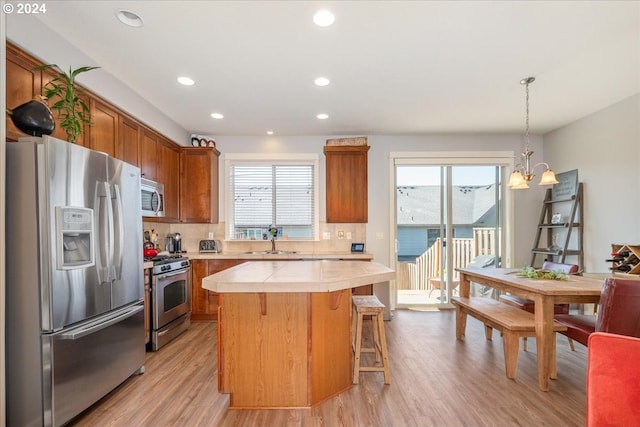 kitchen with appliances with stainless steel finishes, tasteful backsplash, and a healthy amount of sunlight