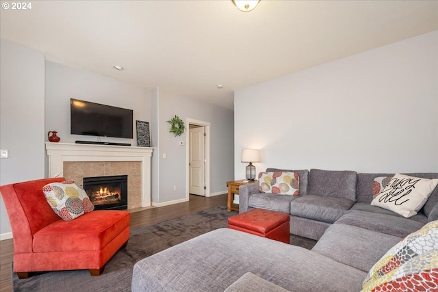 living room with a tiled fireplace and dark hardwood / wood-style floors