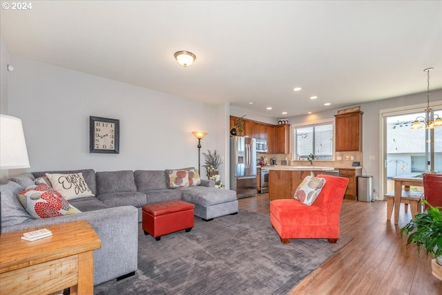 living room with hardwood / wood-style floors and a notable chandelier