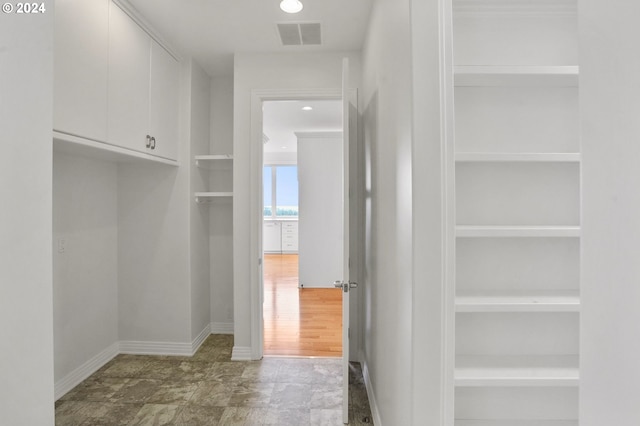 walk in closet with hardwood / wood-style floors