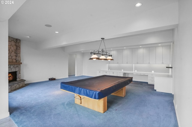 game room with pool table, built in desk, a fireplace, and dark colored carpet