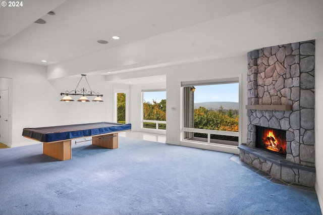 rec room featuring a stone fireplace, pool table, and dark colored carpet