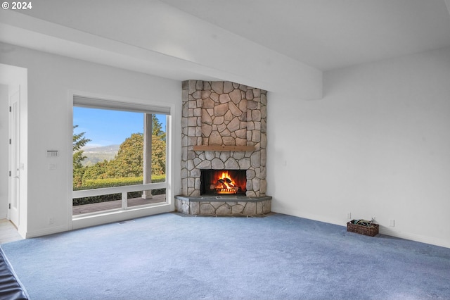 unfurnished living room with carpet and a stone fireplace