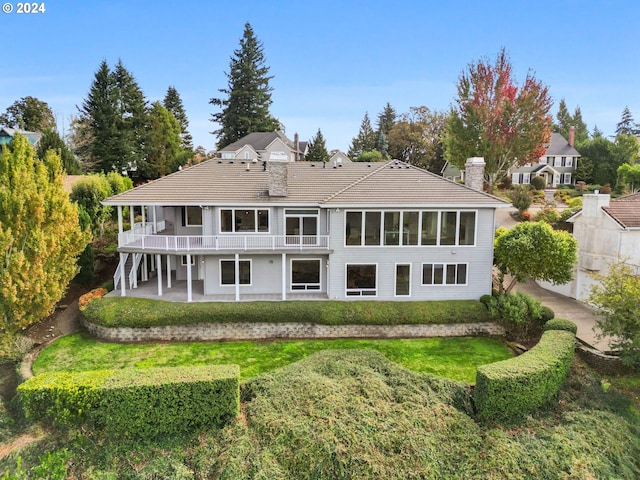 back of property featuring a patio and a lawn