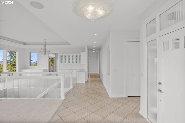 corridor with light tile patterned flooring and an inviting chandelier