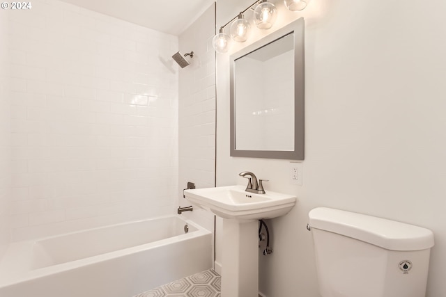 bathroom with toilet and tiled shower / bath