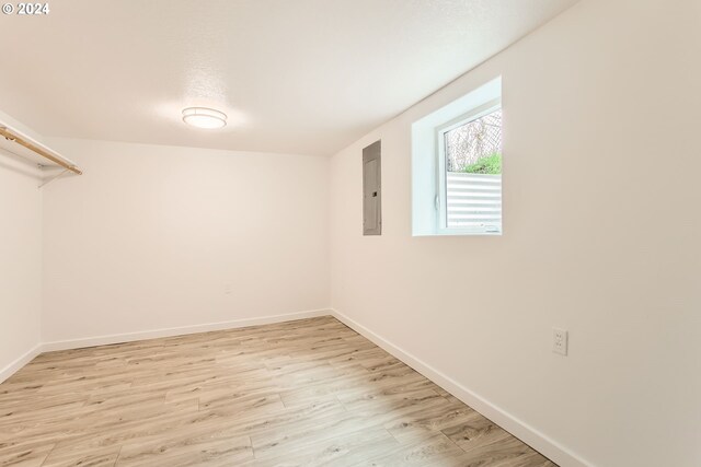 interior space with electric panel and light hardwood / wood-style flooring