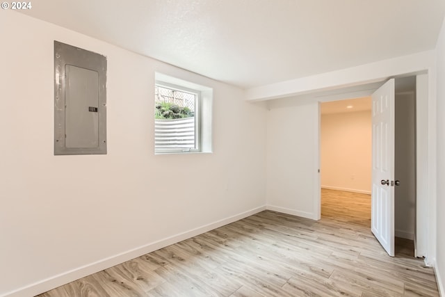 spare room with light hardwood / wood-style floors and electric panel