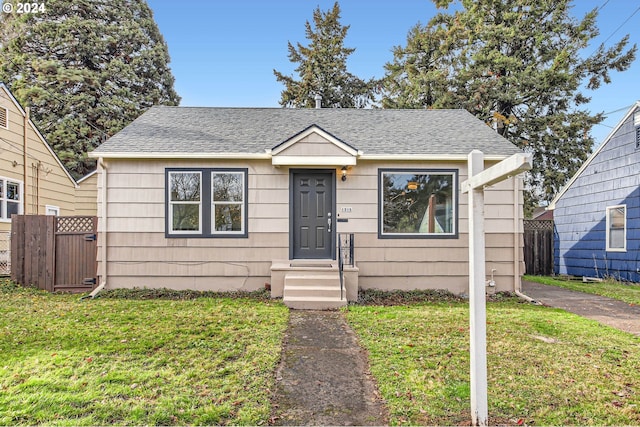 bungalow-style home with a front yard