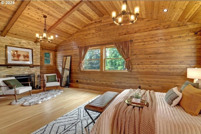 bedroom featuring hardwood / wood-style flooring, a fireplace, a chandelier, and wooden walls