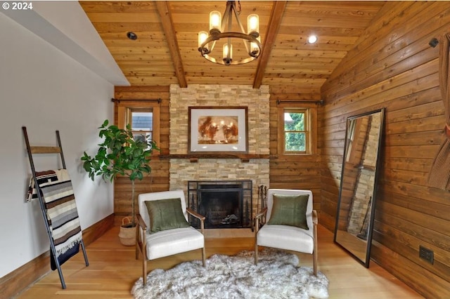 living area featuring a fireplace, an inviting chandelier, lofted ceiling with beams, wood ceiling, and wood-type flooring