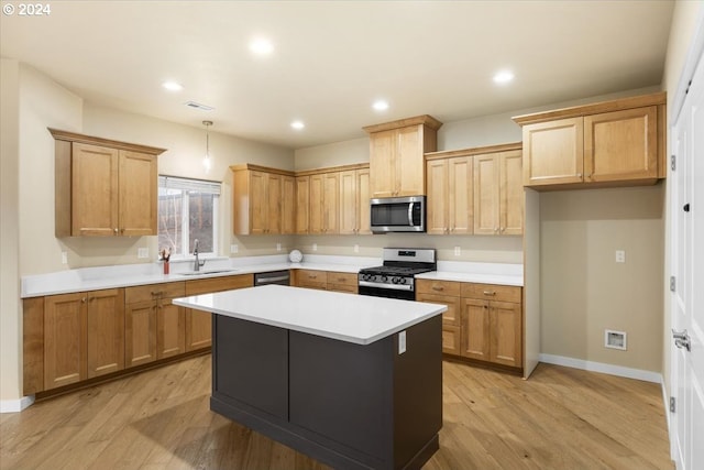 kitchen featuring a center island, light wood-type flooring, sink, and appliances with stainless steel finishes