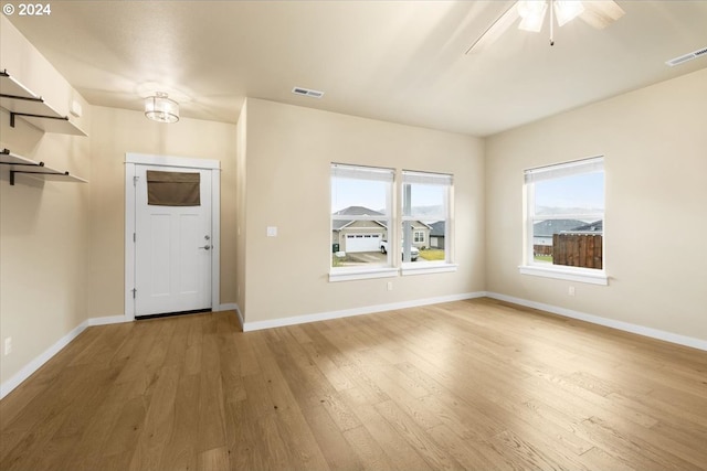 entrance foyer with ceiling fan with notable chandelier and light wood-type flooring