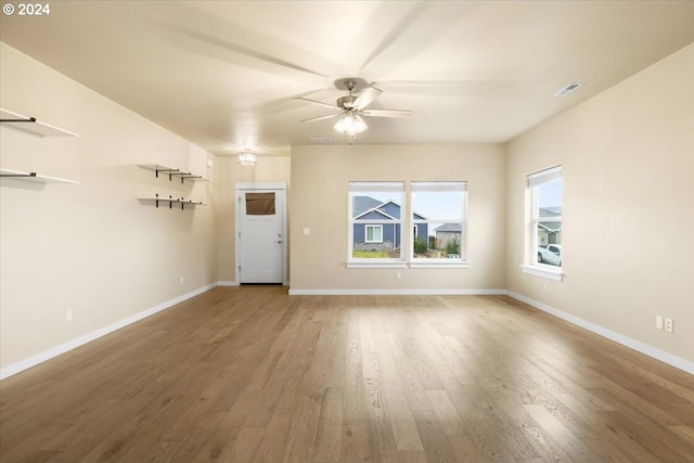 unfurnished living room featuring ceiling fan and hardwood / wood-style flooring