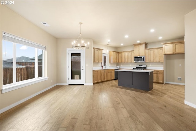 kitchen featuring a center island, light wood-type flooring, stainless steel appliances, and a chandelier