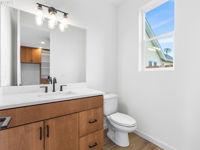 bathroom with vanity, wood-type flooring, and toilet