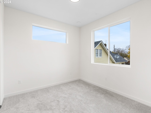 carpeted spare room featuring a healthy amount of sunlight