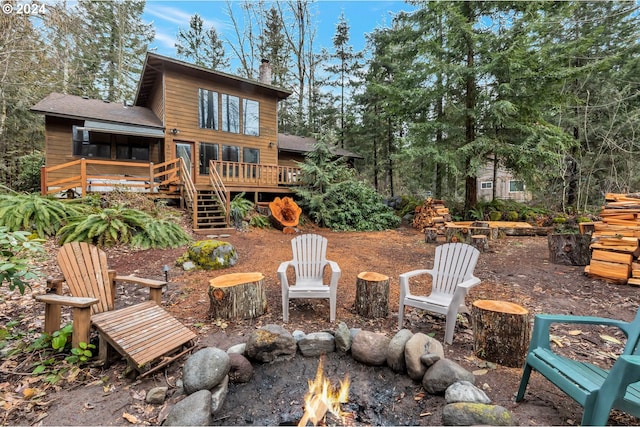 rear view of property with a fire pit and a wooden deck