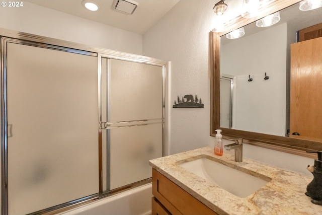 bathroom featuring shower / bath combination with glass door and vanity